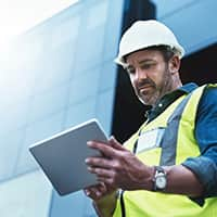 Stack of hard hats with a hand resting on top