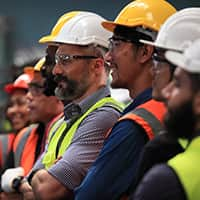 Workers in hardhats and safety glasses