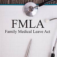 Family and Medical Leave Act printed on paper with a pen and stethoscope lying on the page