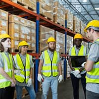 Warehouse workers in safety gear brainstorming