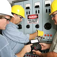 Electricians around high voltage with a testing device