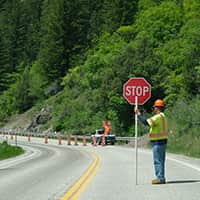 A man displays a stop sign, emphasizing the importance of road safety and traffic control.