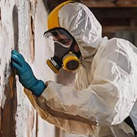 Asbestos Removal Specialist Carefully Dismantling Hazardous Materials in Old Building